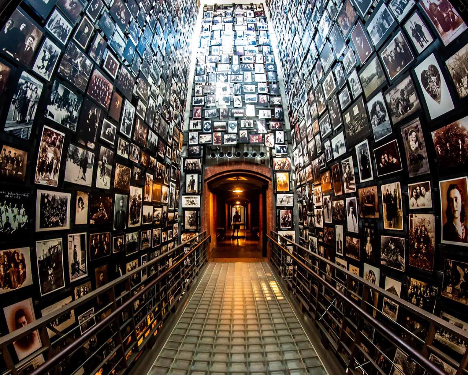 US Holocaust Museum photo of a hallway with floor to ceiling photographs of concentration camp victirms