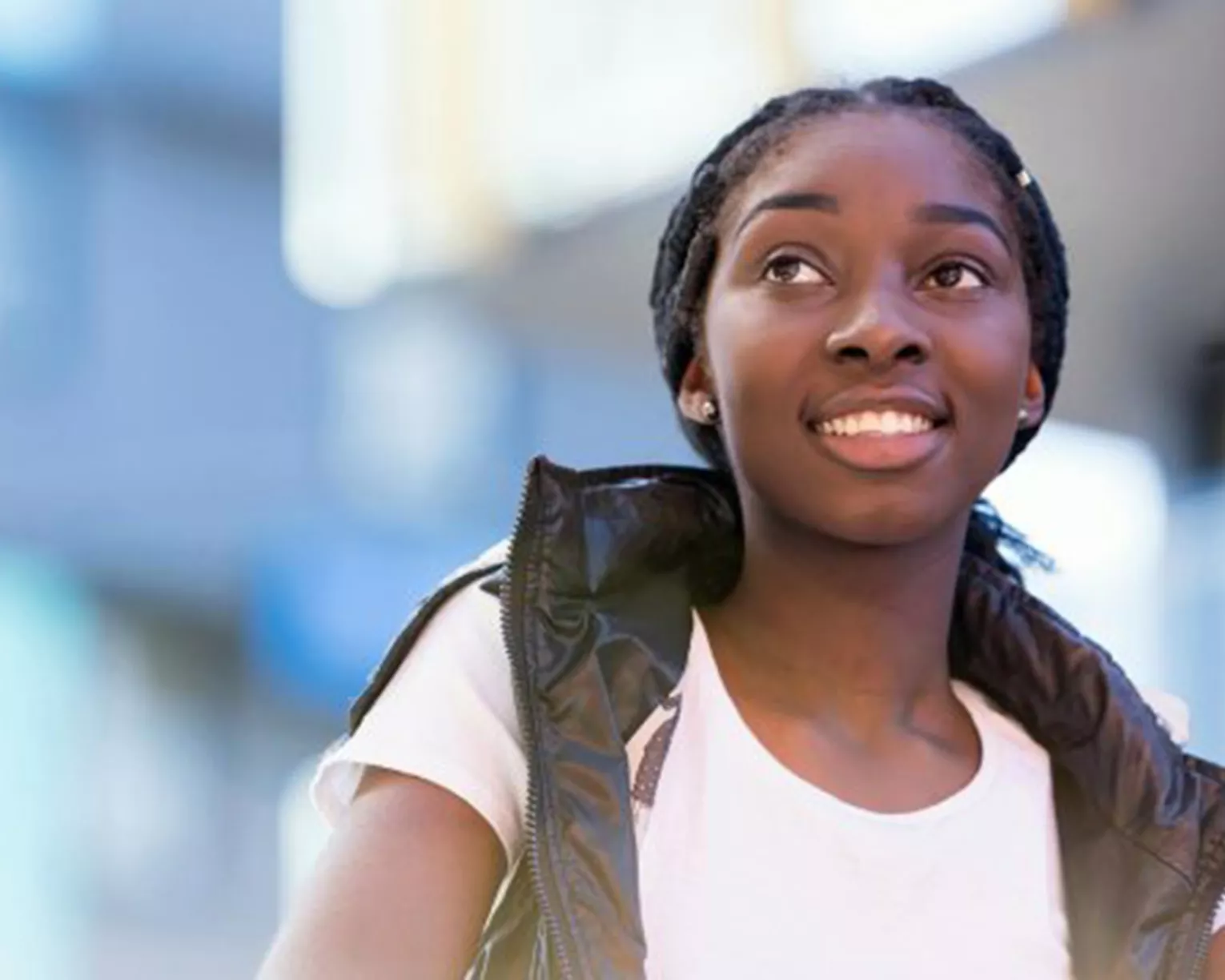 african american girl smiling and wearing a white tshirt and black vest