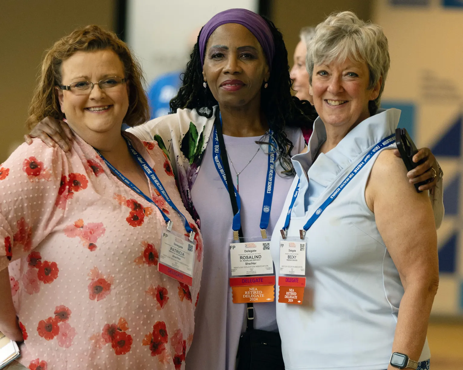three women standing and posing for a photograph in a hotel lobby
