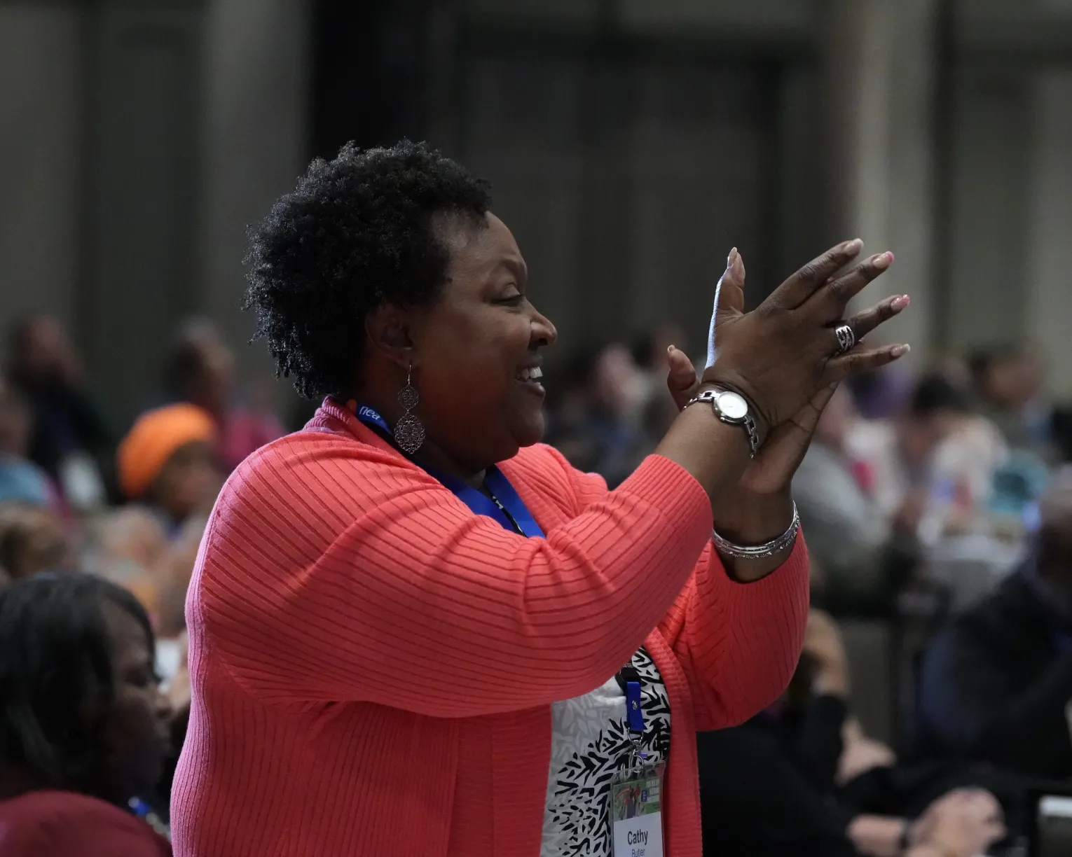 african american woman giving a standing ovation in an audience