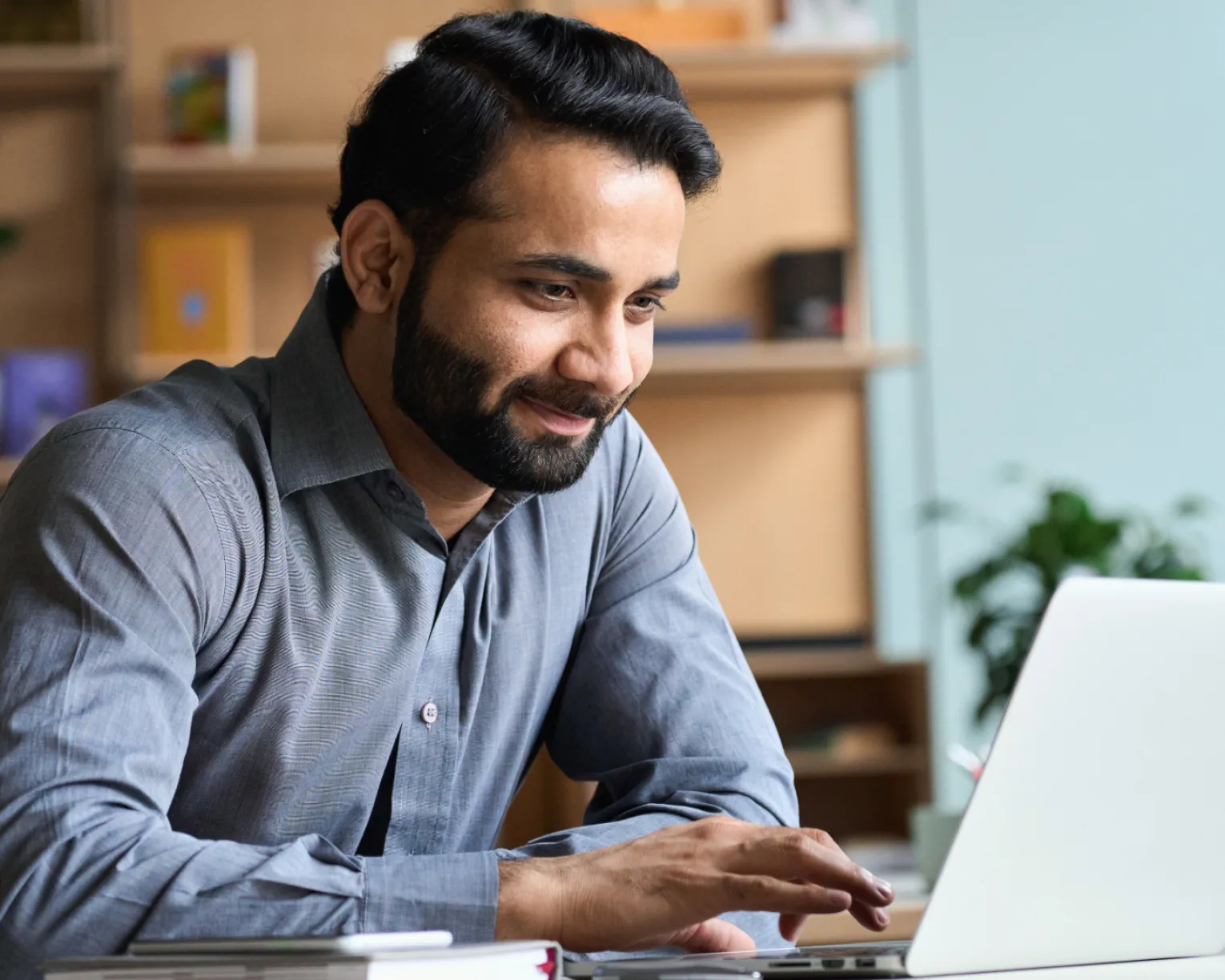 A man sits using a laptop.