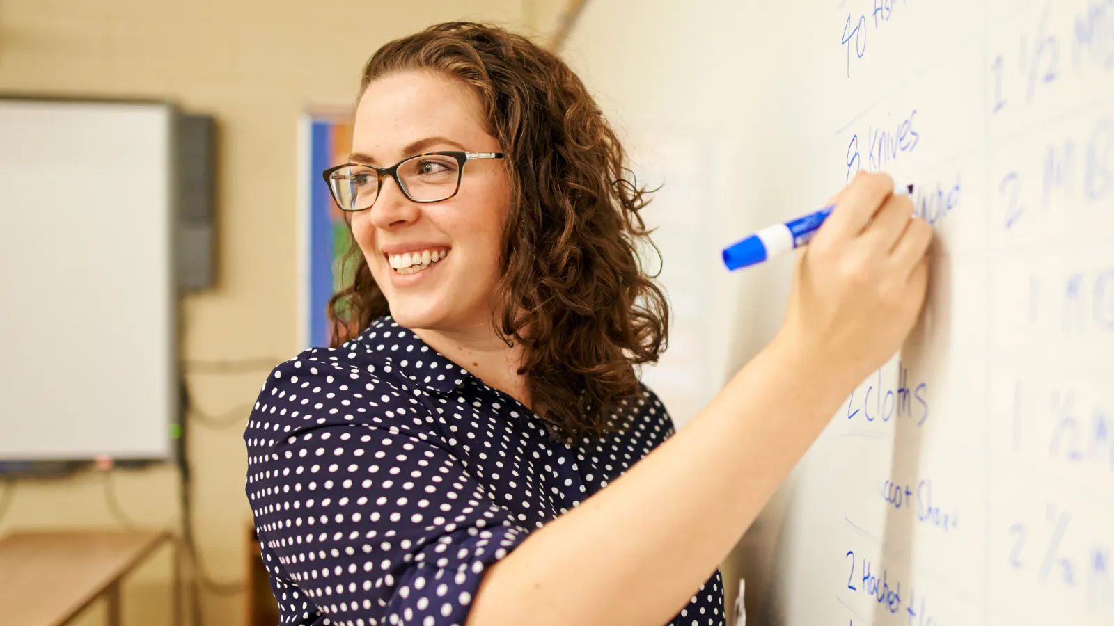 Educator writing on whiteboard
