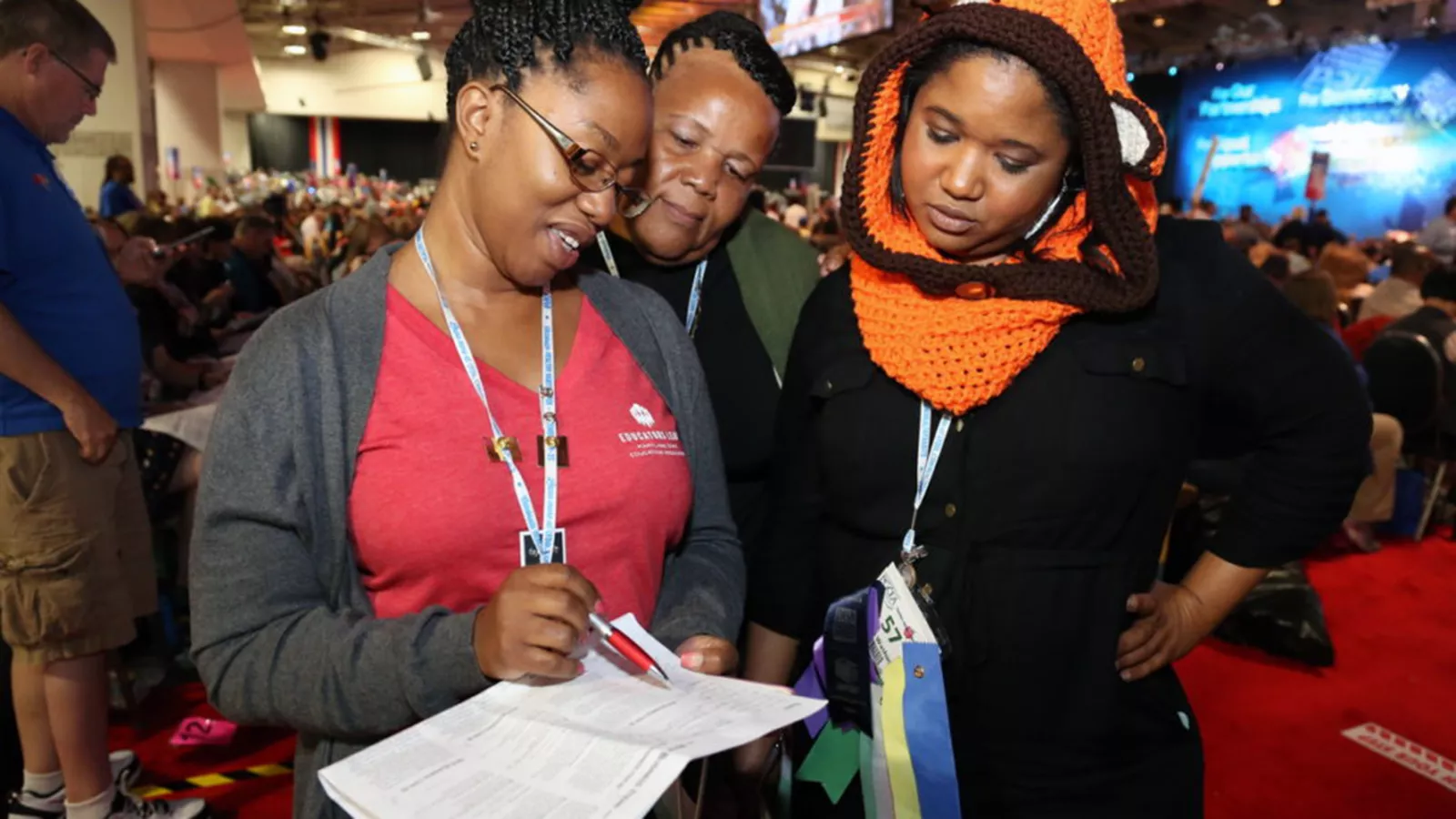 Three RA delegates at the NEA convention look over a copy of the daily conventions newspaper.