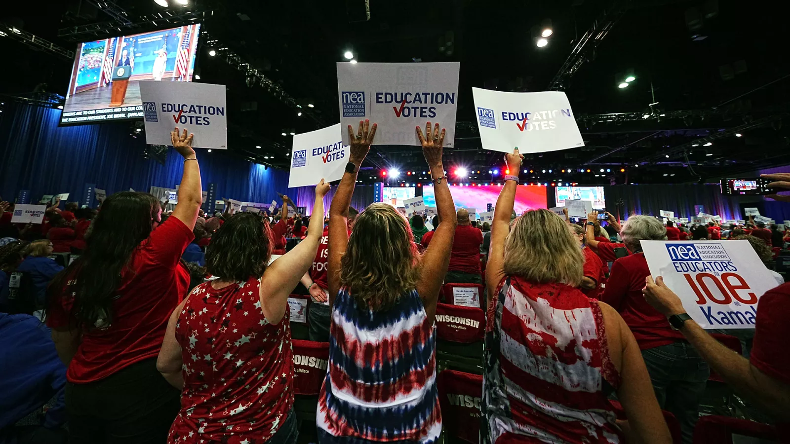 Delegates to the 2023 NEA RA hold up signs saying Education Votes