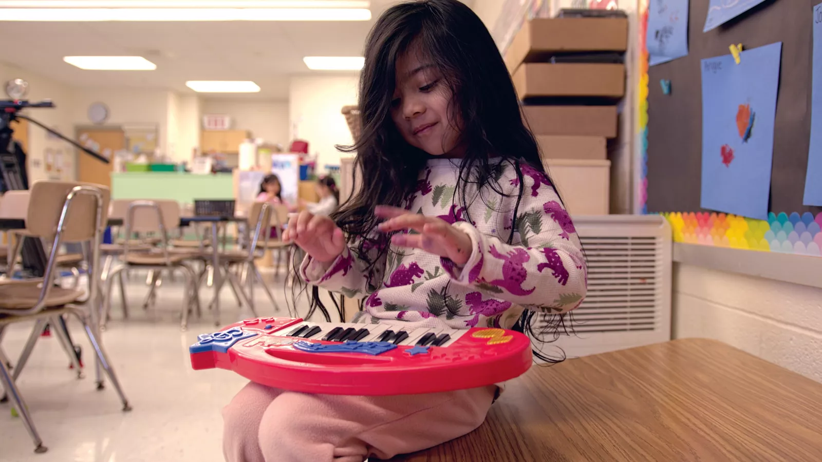 A preschool student explores music with a keyboard