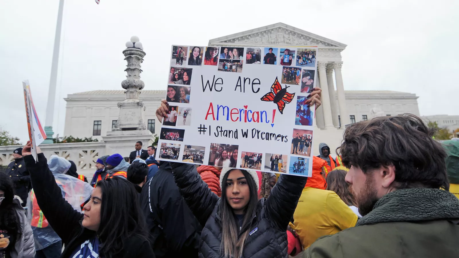 Protester holds up sign that says We Are American at rally in DC