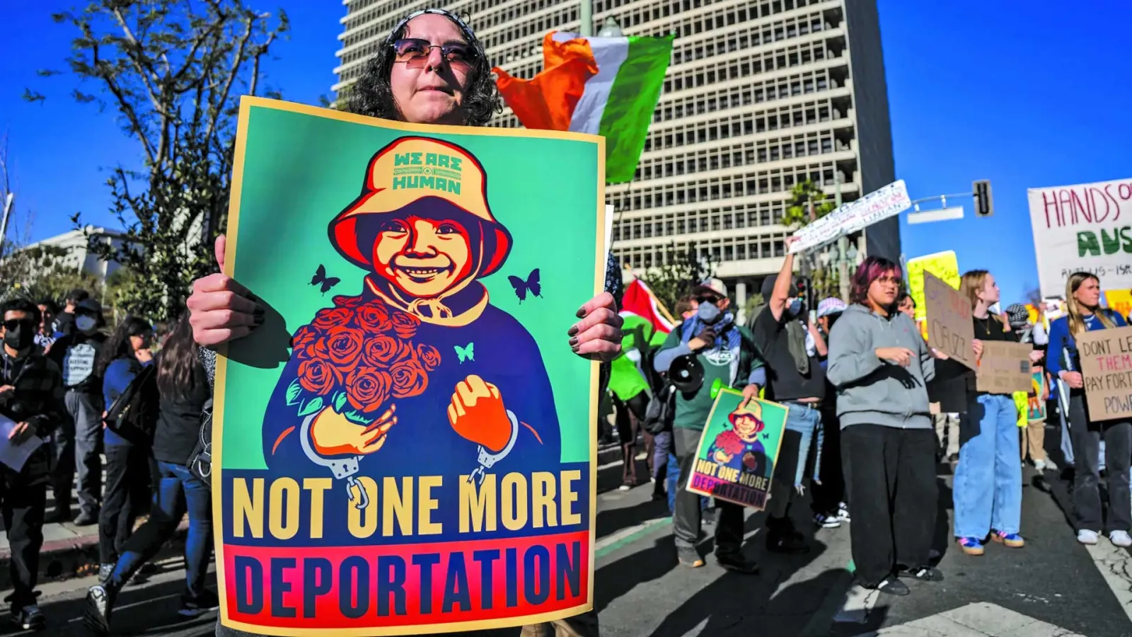 Female Latinx protester holding up a sign saying Not One More Deportation