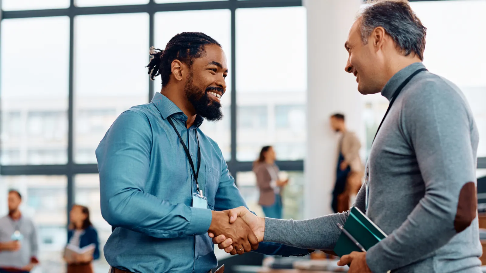 Two educators shake hands at a staff event.