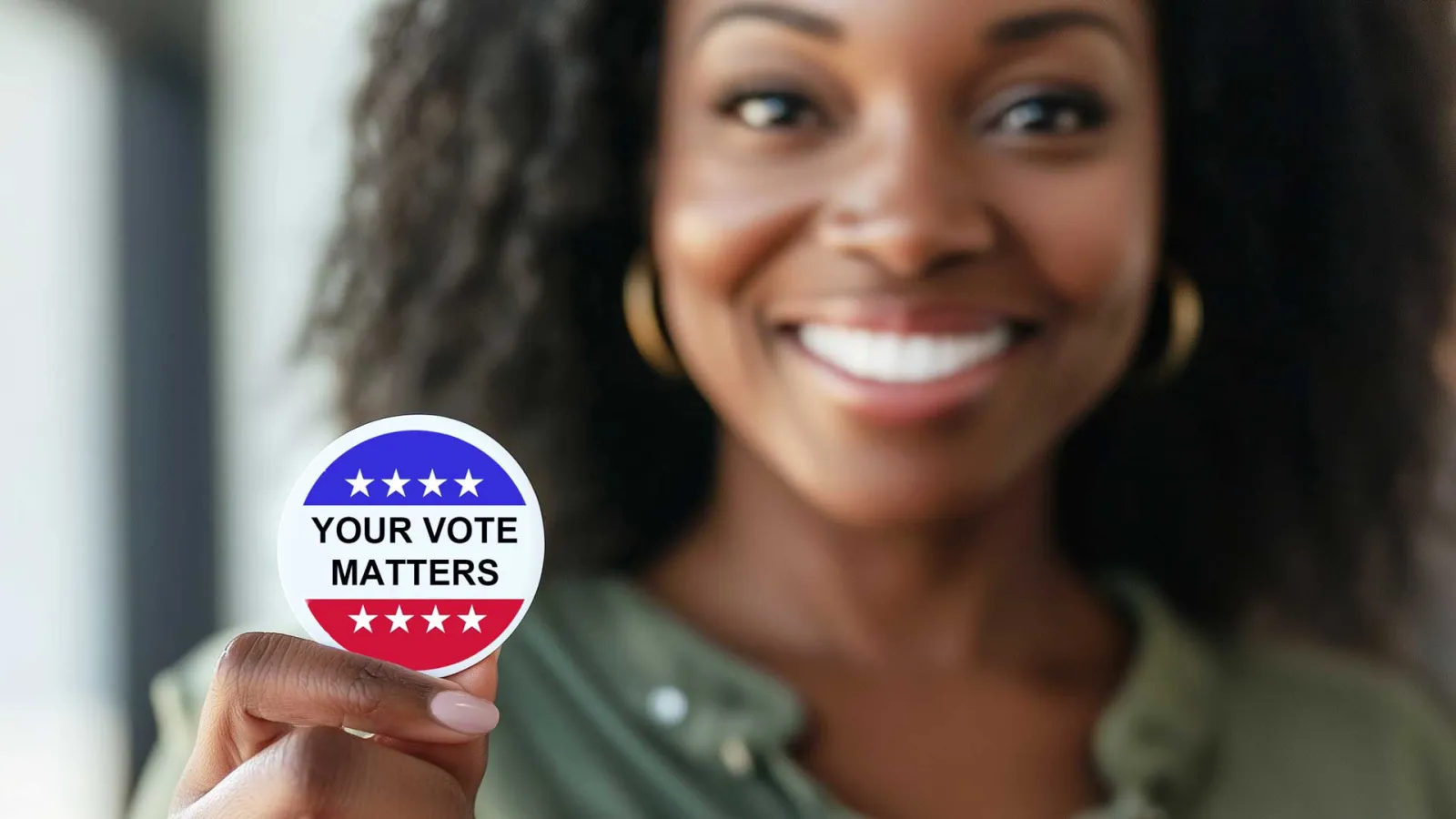 Black women smiling and holding a Your Vote Matters sticker.
