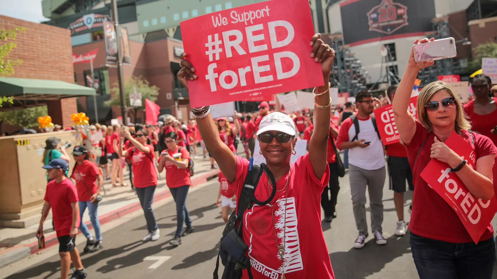 Woman holding We Support Red for Ed sign