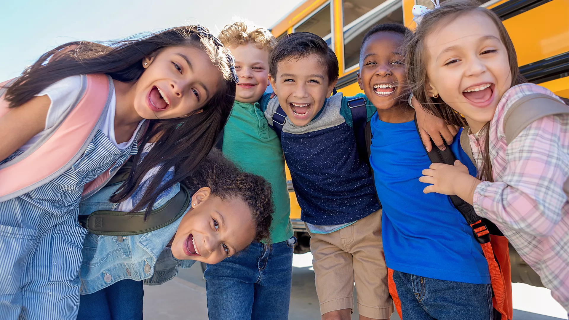 Group of schoolchildren in front of school bus