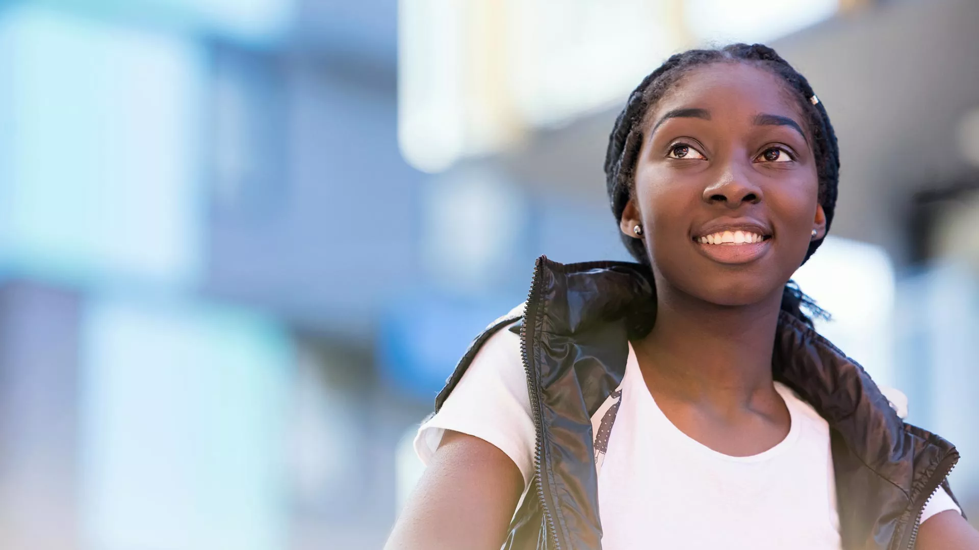 An African-American girl smiles in a school hallway