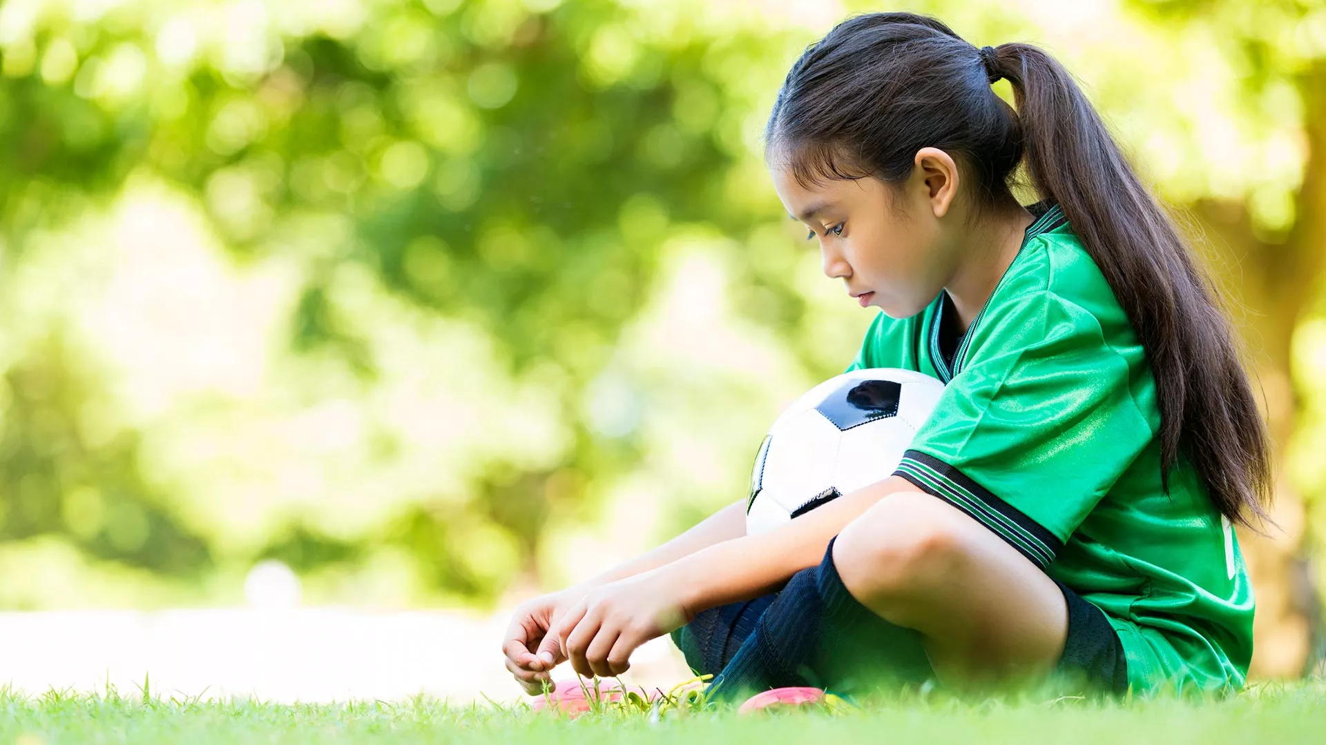 An Asian American girl sits alone