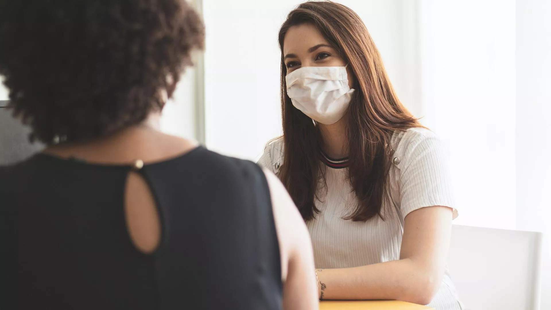 Two teachers wearing masks converse