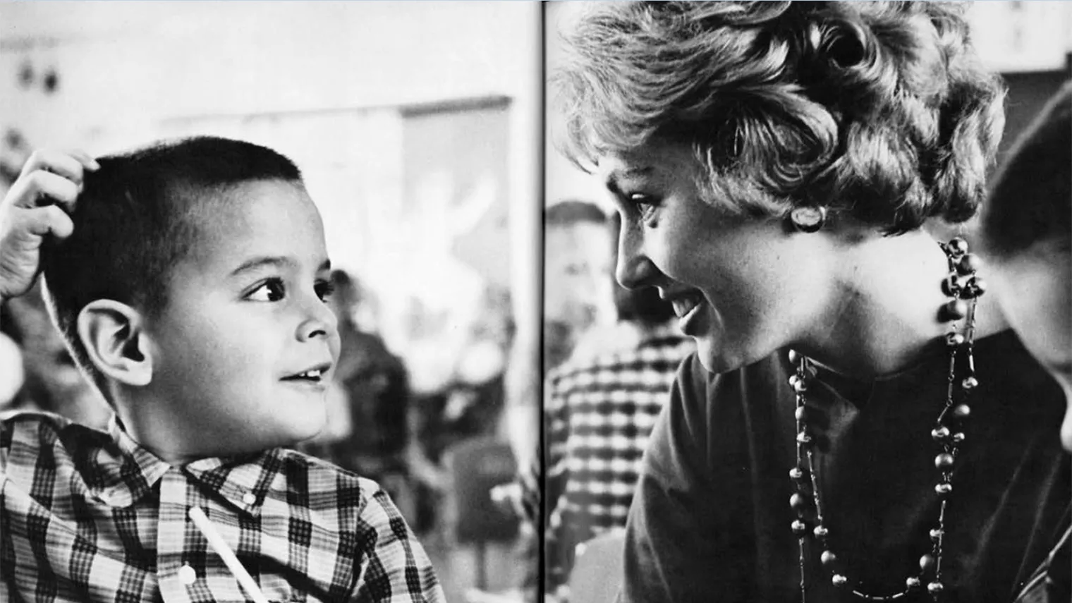 Teacher with student in 1950s classroom