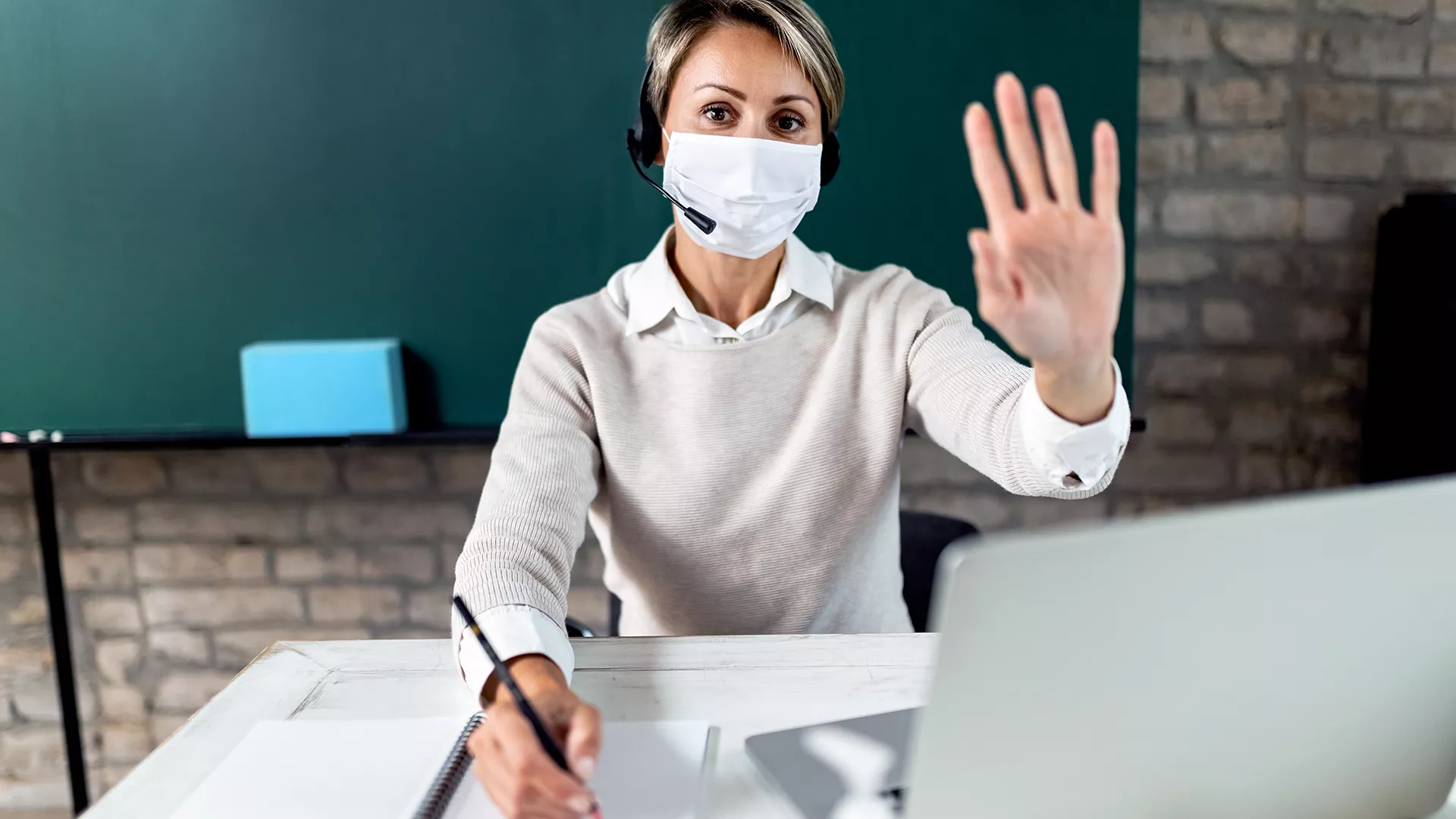 teacher with mask at her desk