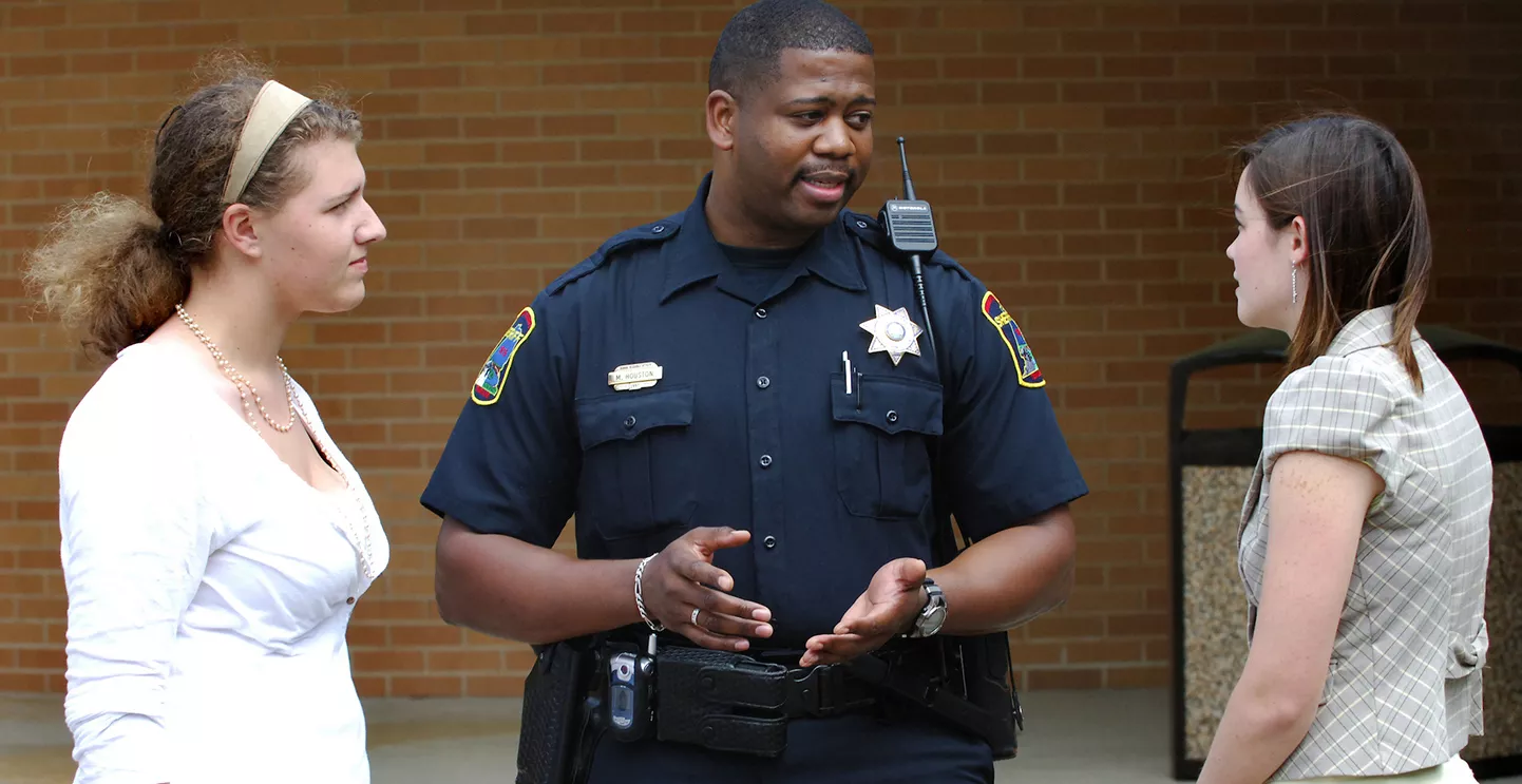 A police officer speaks to two young women