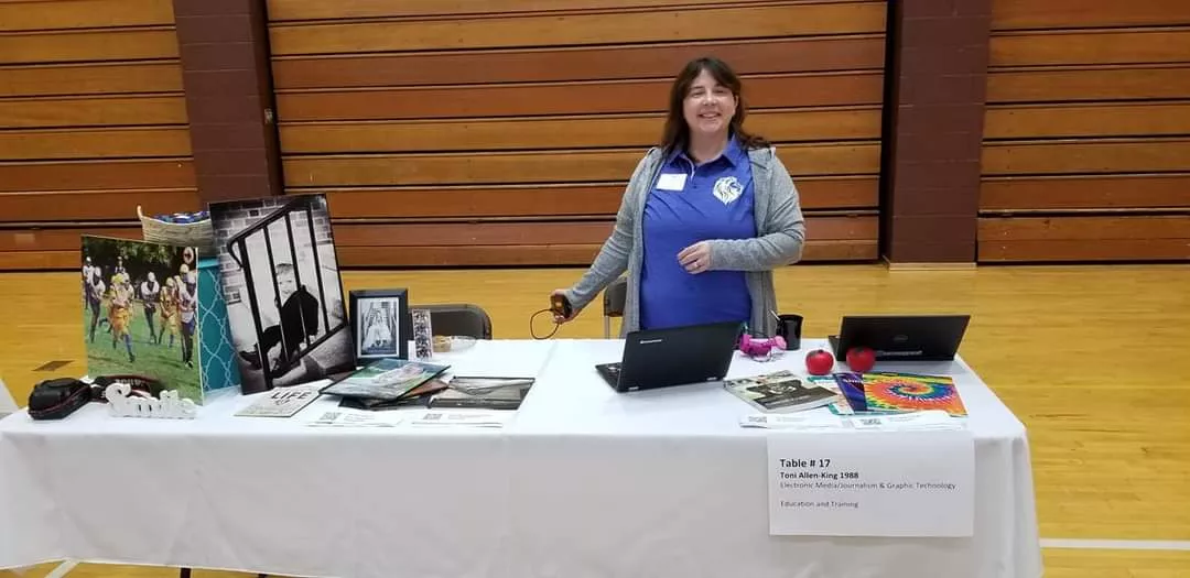 Photo of Toni Allen-King behind a table.