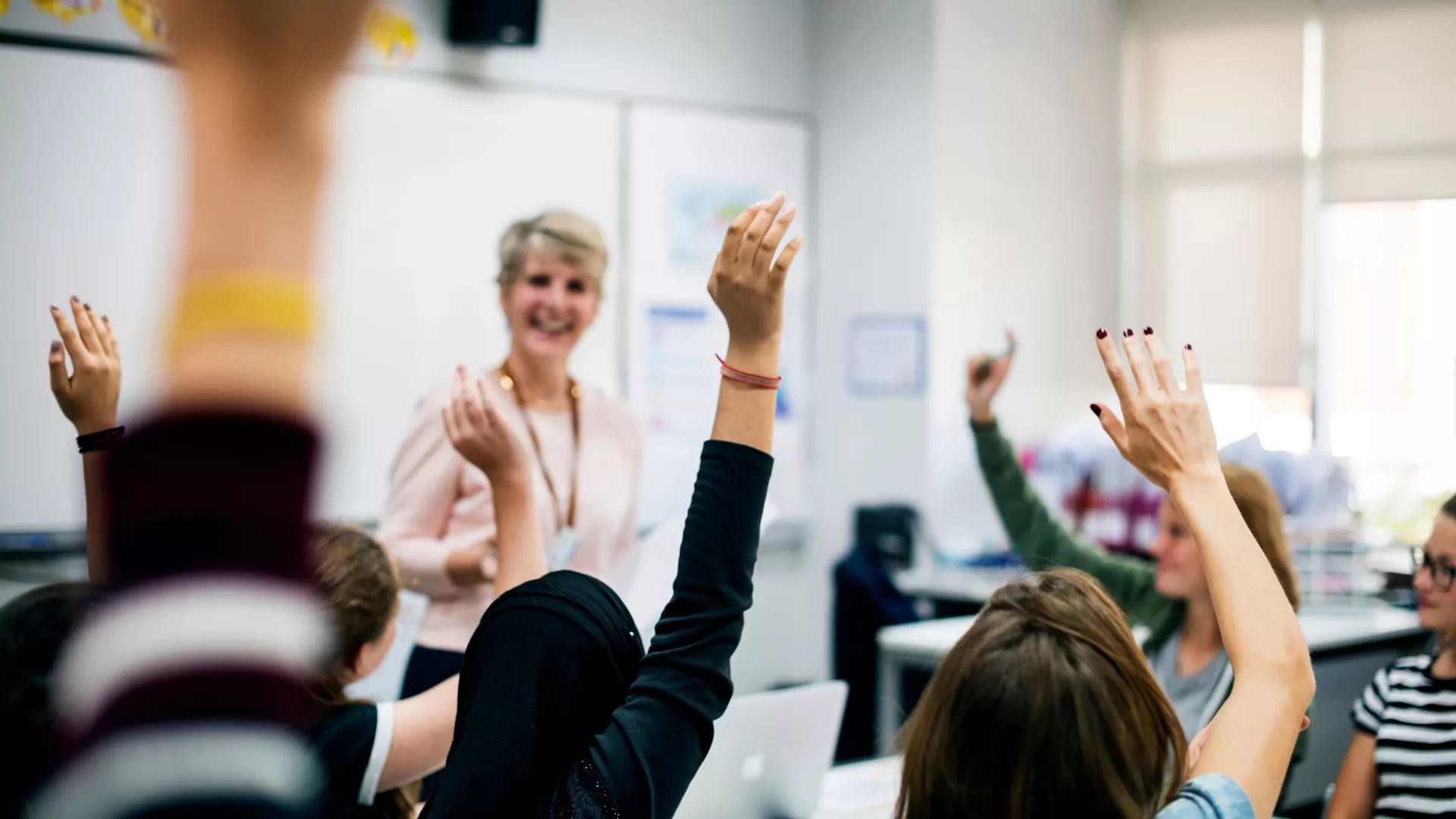teacher with classroom raising hands