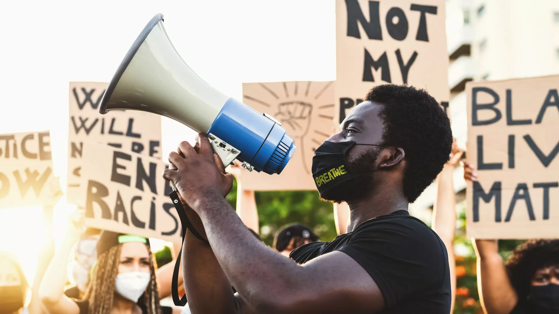 A Black man holds a megaphone at a Black Lives Matter rally/