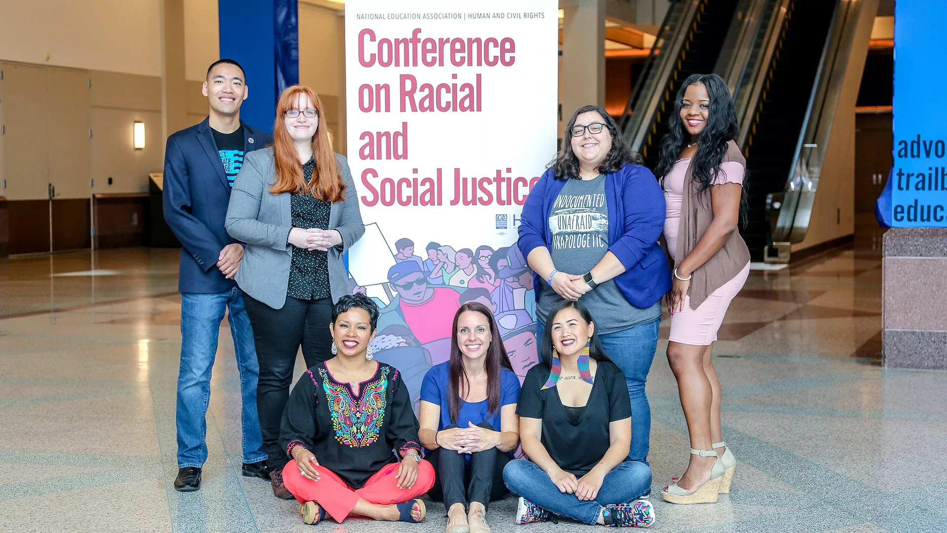 winners of the NEA social justice activist award pose before a sign for the Conference on Racial and Social Justice