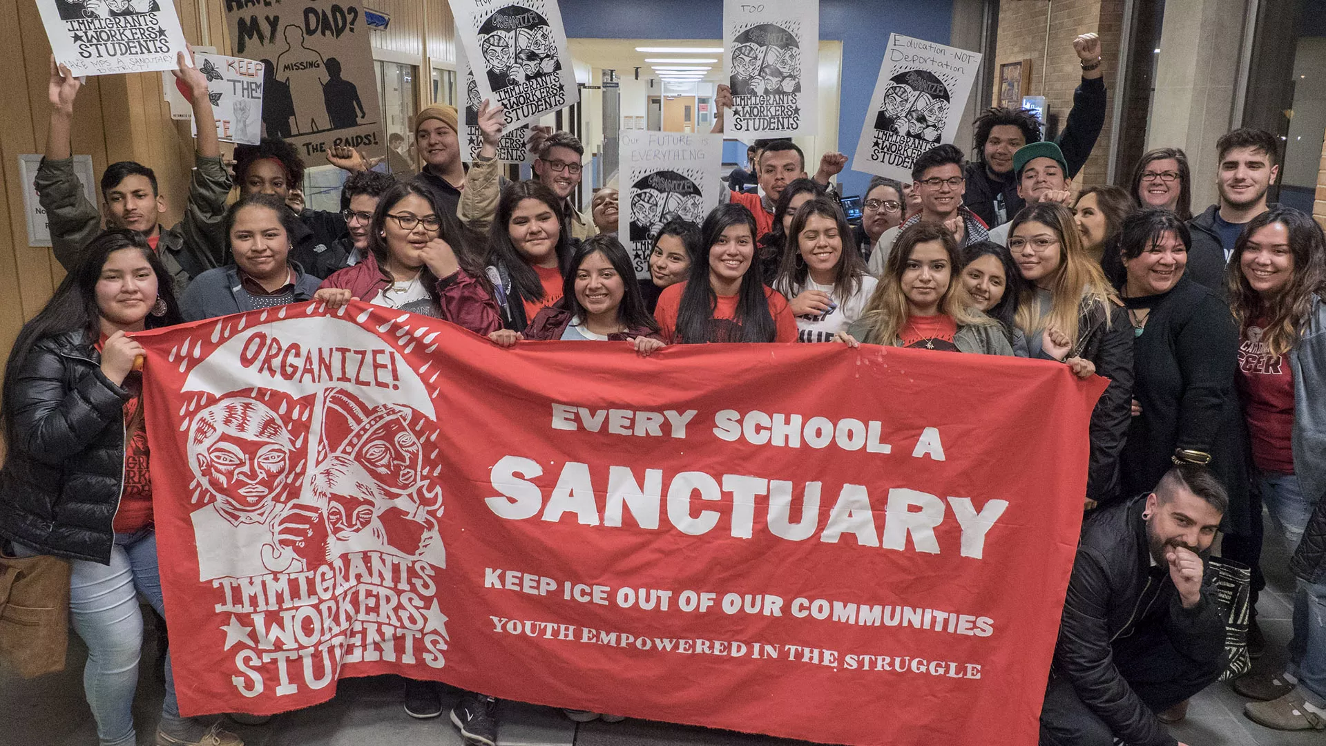 Students with an orange banner saying Every School a Sanctuary