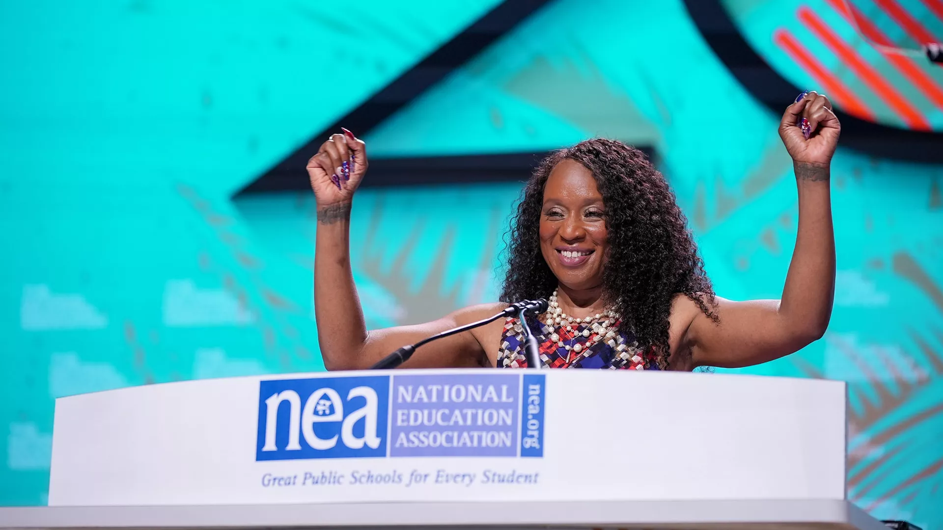 ESP of the Year Pamella Johnson raises her arms as she addressed the 2023 NEA Representative Assembly