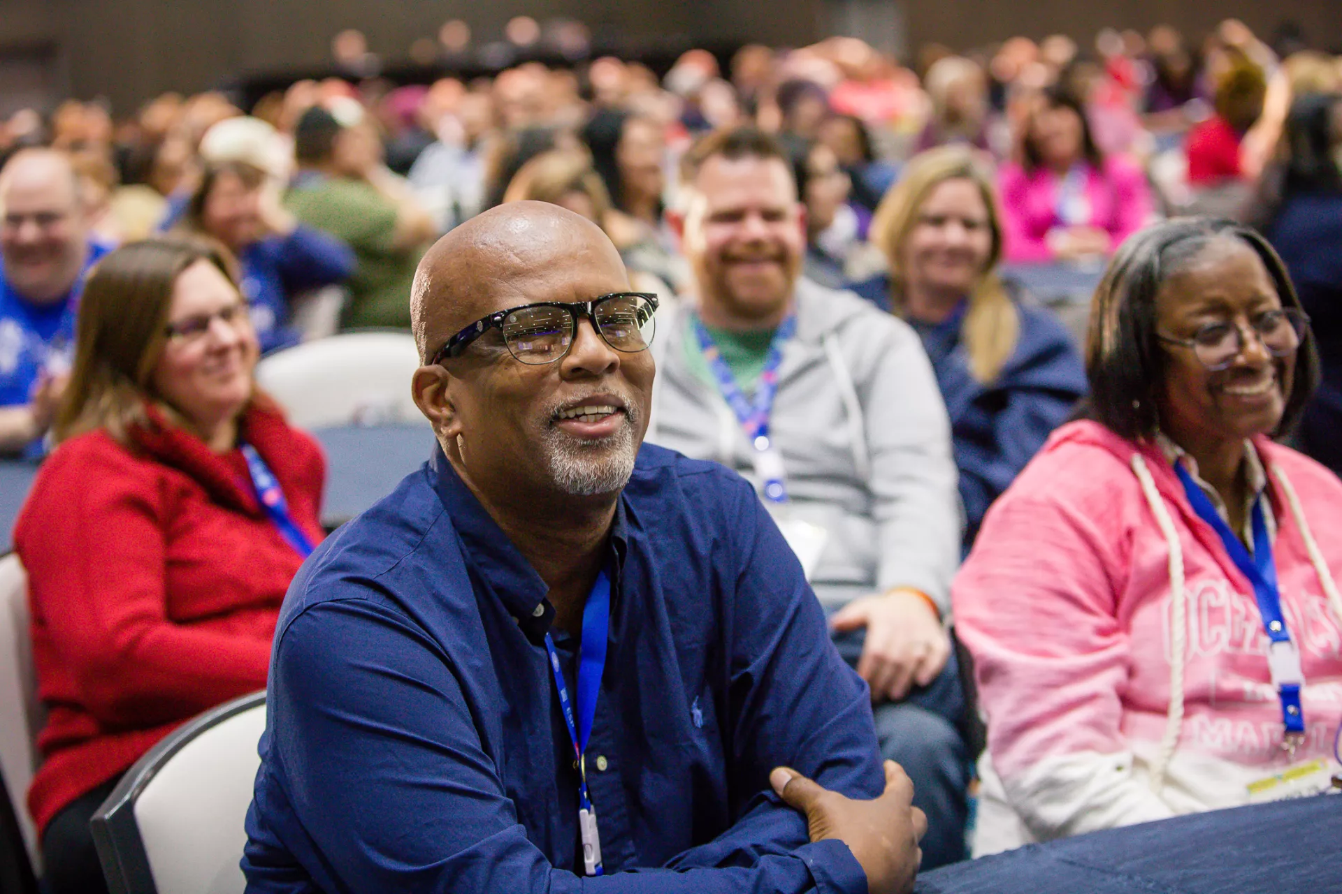 photo of NEA members in an audience smiling and listening to a speaker