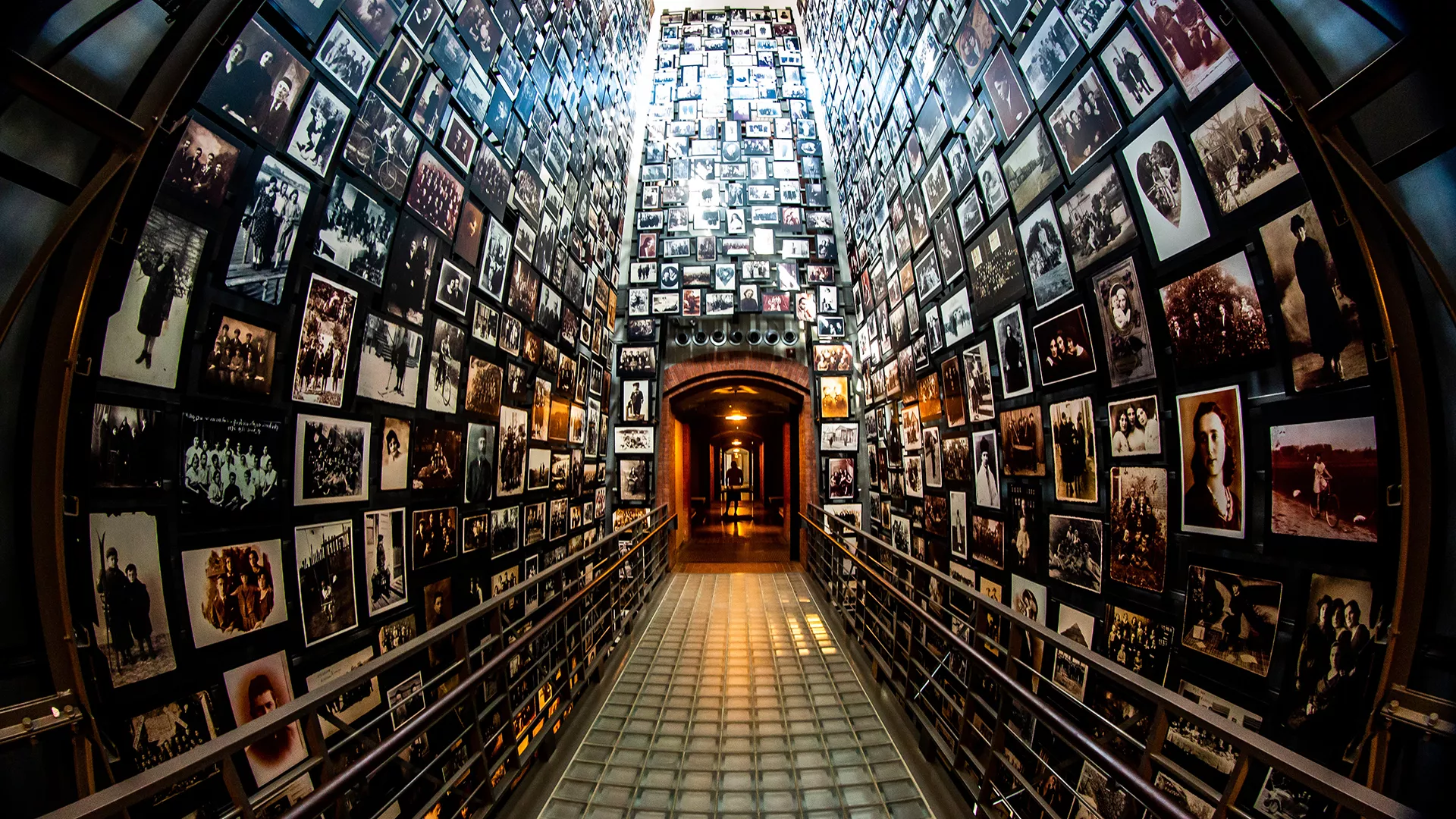 US Holocaust Museum photo of a hallway with floor to ceiling photographs of concentration camp victirms
