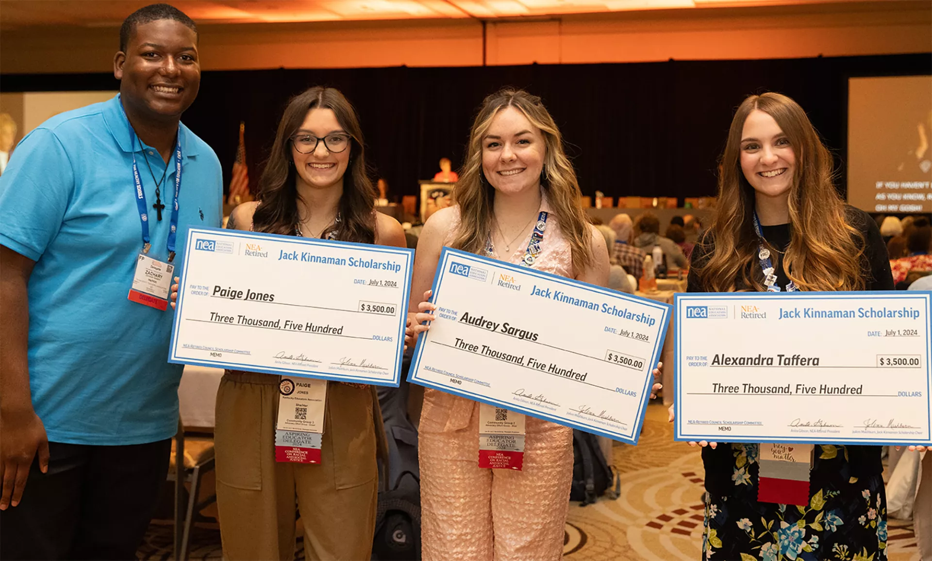 Three of four future teachers hold a large check, showcasing their scholarship award.