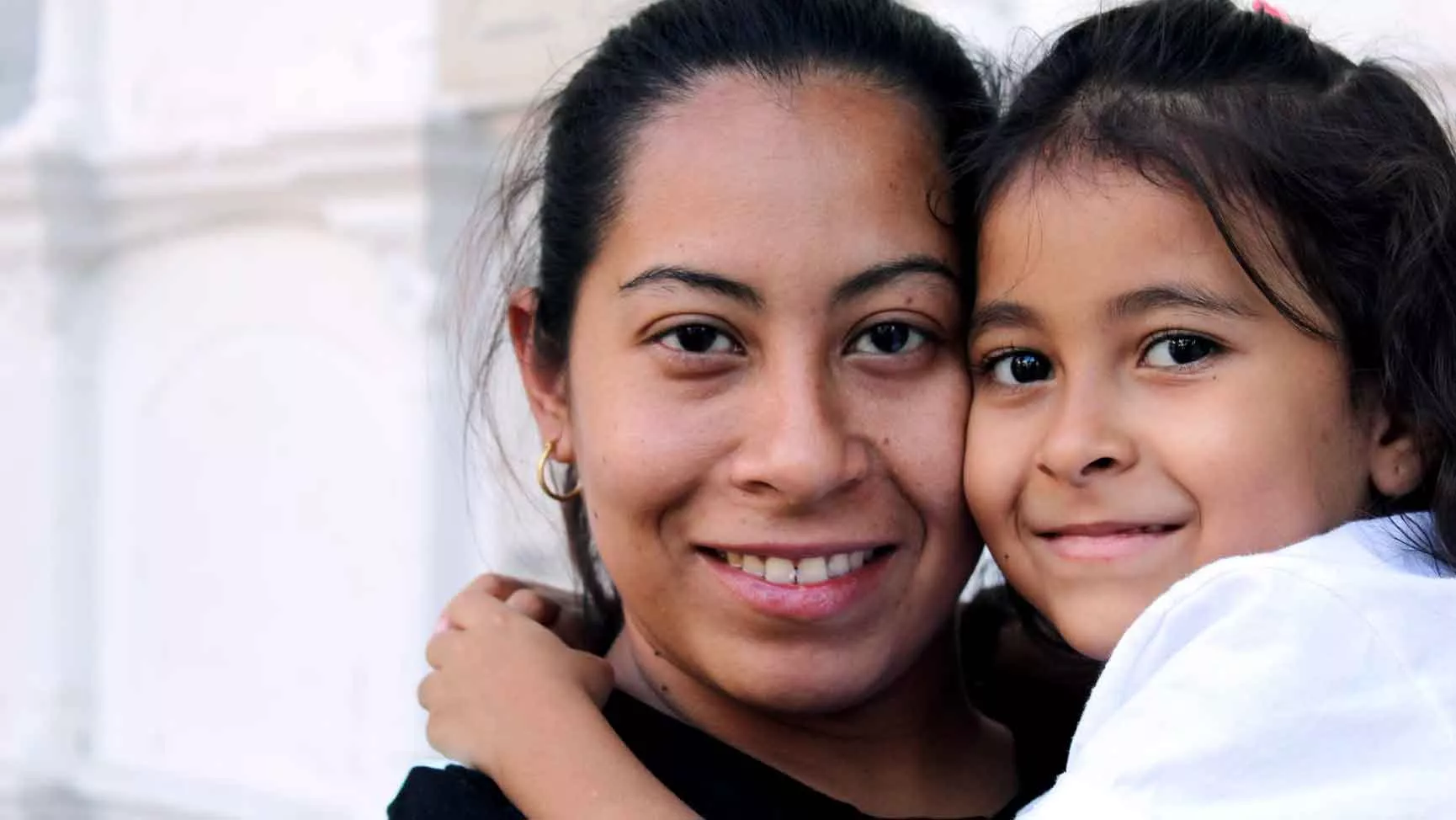 An immigrant mother and daughter smiling