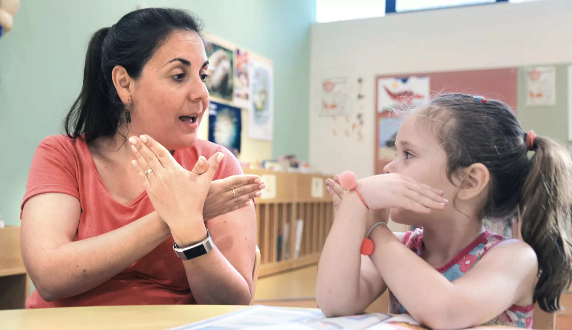 educator uses sign language with a young student