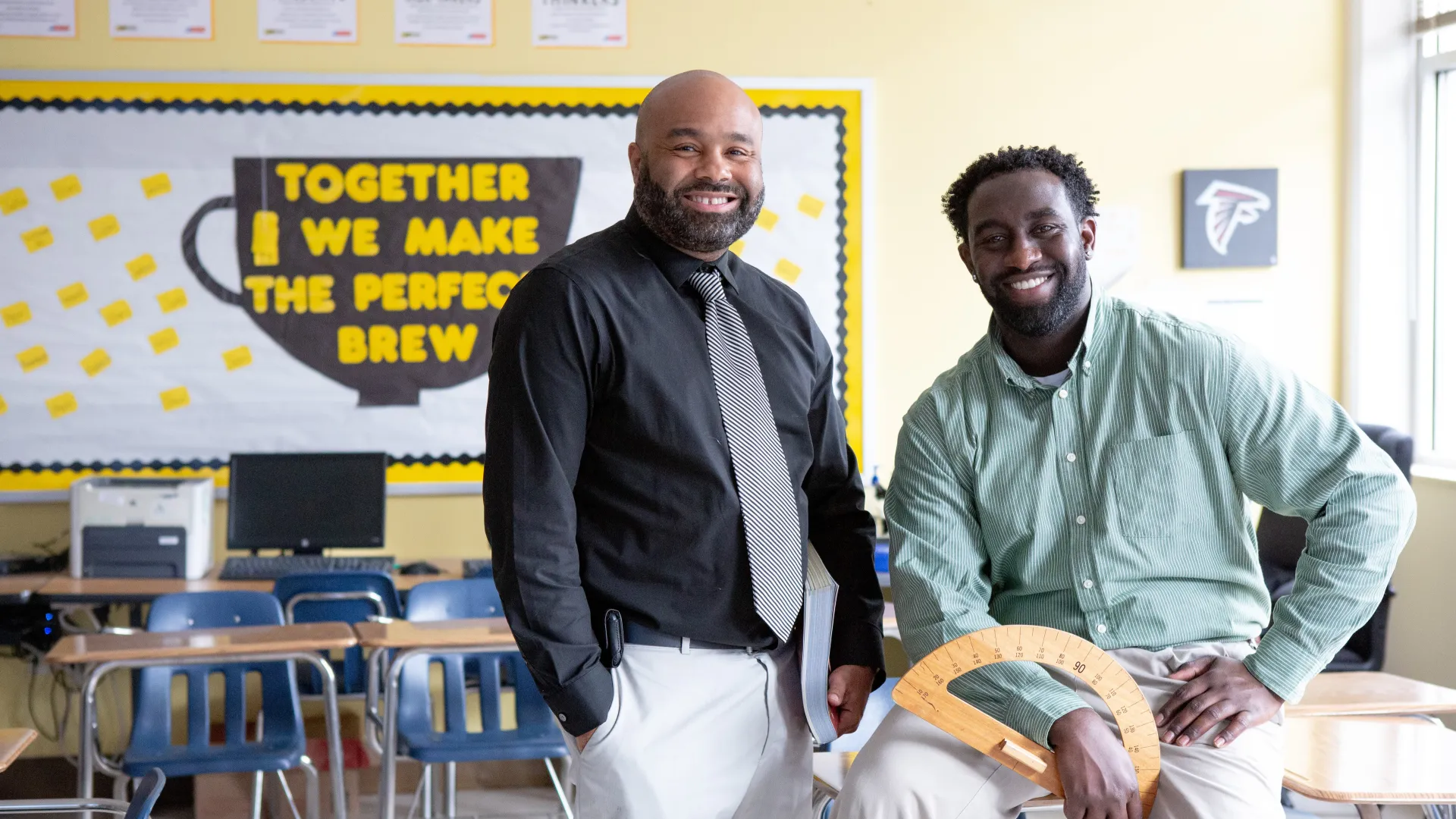 Two teachers spend their break together and smile at the camera.