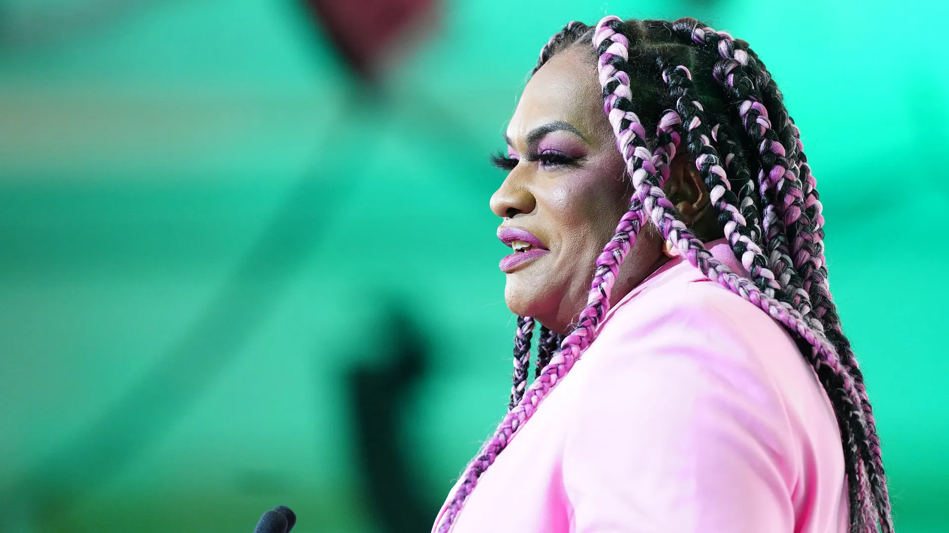 The profile of a woman in a pink jacket.