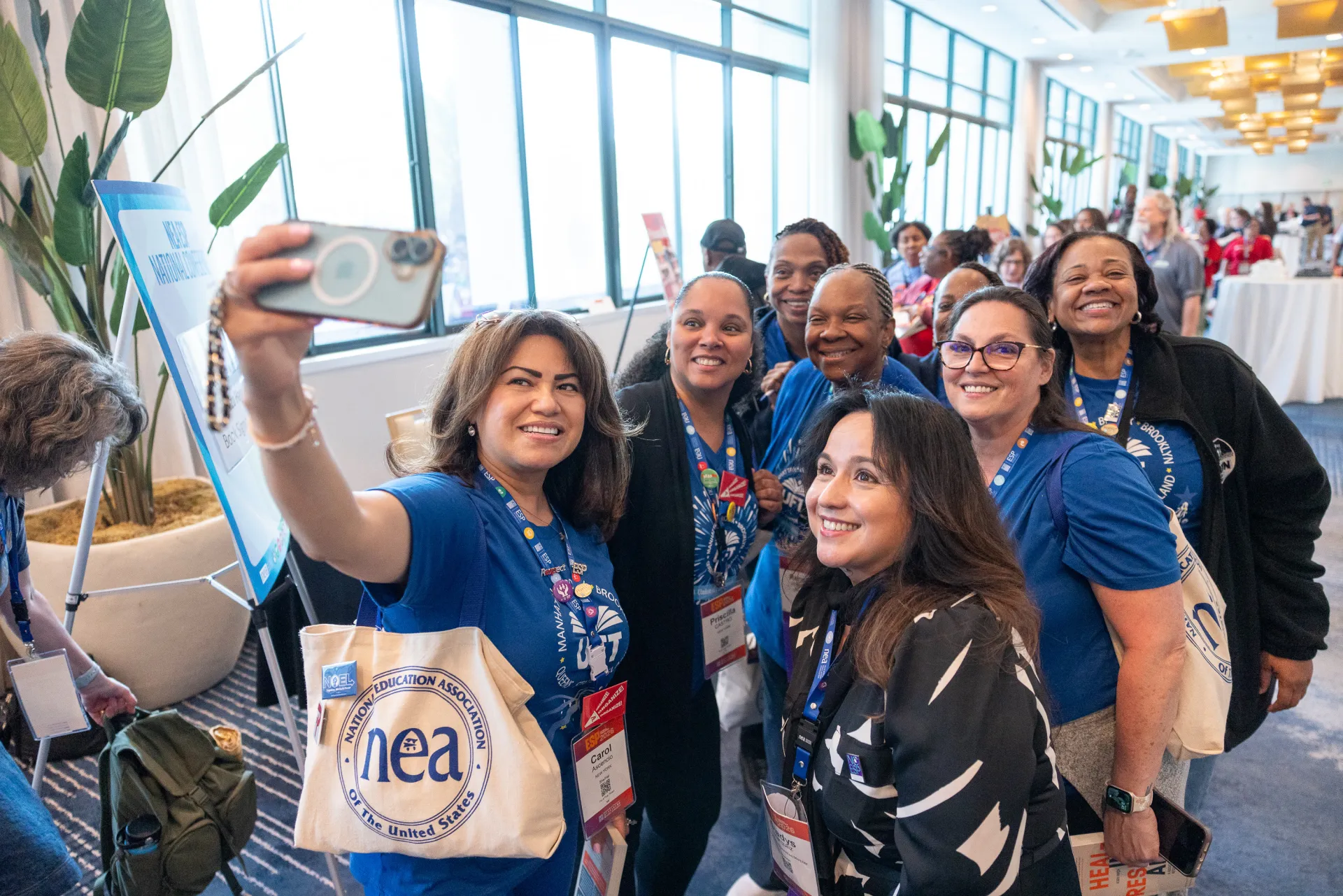 A group of 8 educators of color smiling for a selfie