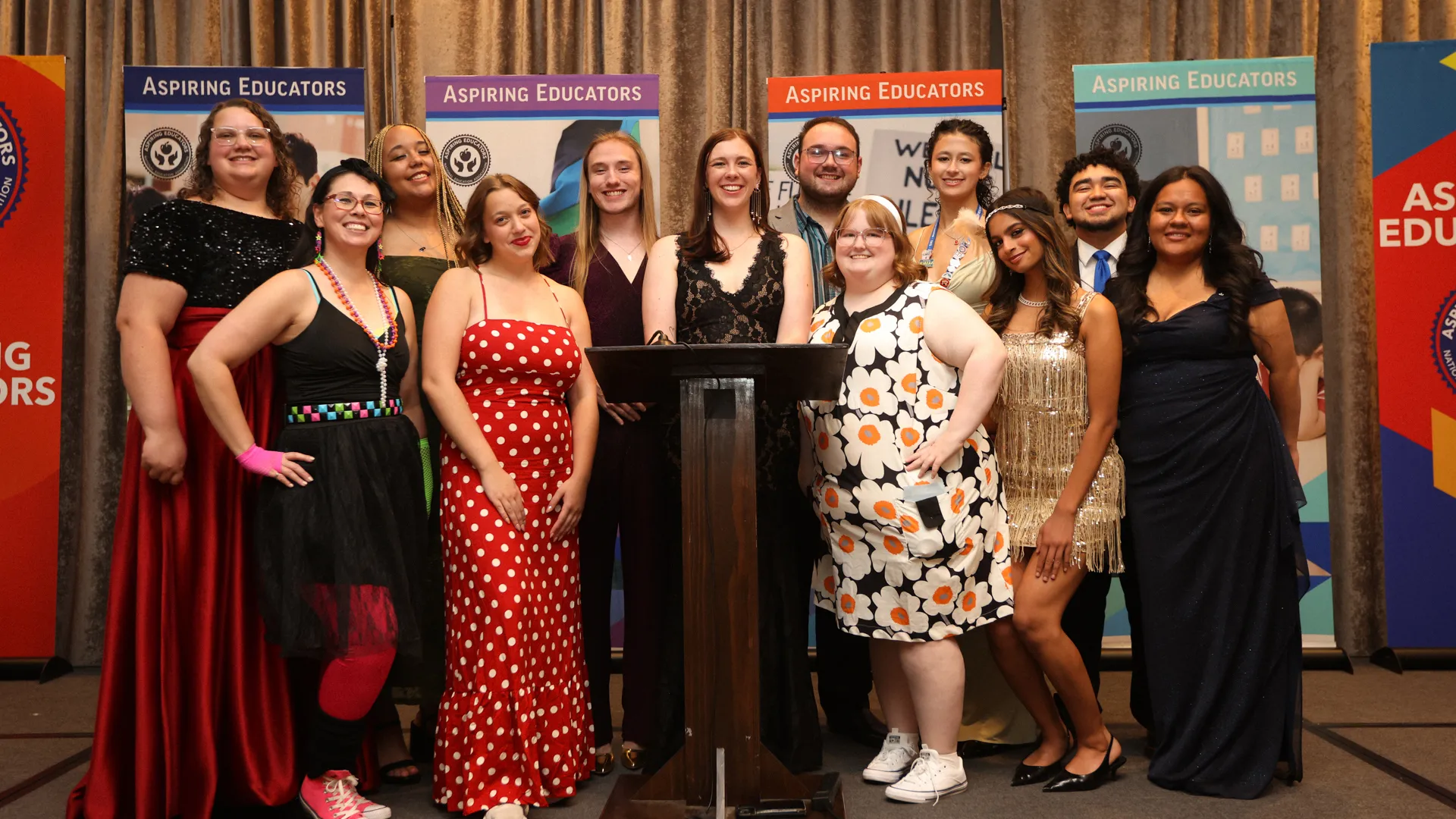 A group of people dressed in formal attire pose for a photo.