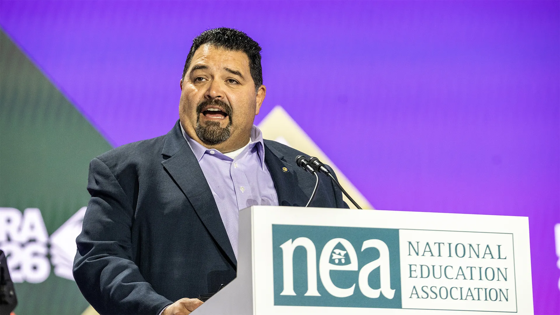 NEA Vice President Noel Candelaria speaks from the stage lectern at the 2026 NEA RA