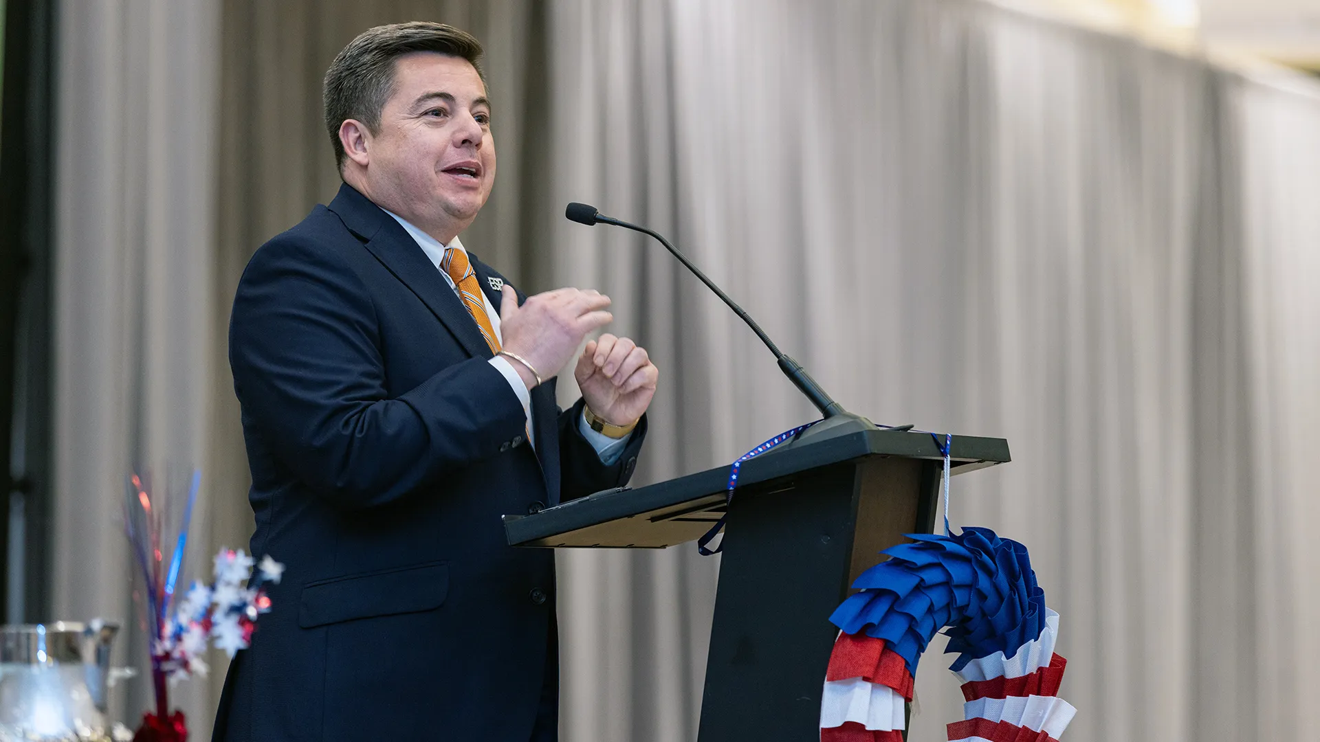 NEA Secretary-Treasurer Robert Rodriguez stands at a lectern and addresses attendees at the NEA Retired Annual Meeting