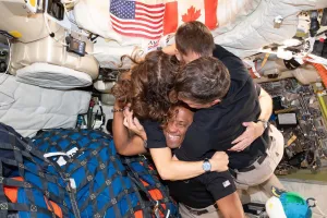 The crew of the Artemis II hugging inside the capsule.