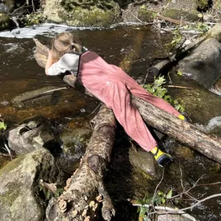 Photo of preschoolers stretched out on log