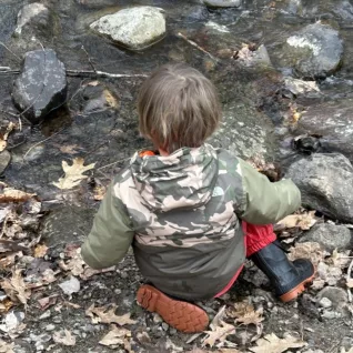 Preschooler looking into river