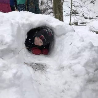 Preschooler in snow hole