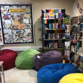 An LGBTQ+ classroom, with multicolor bean bags across the floor.
