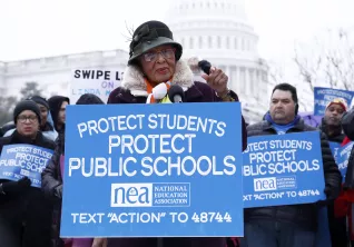 A woman addresses a crowd at a rally with the U.S. Capitol as a backdrop
