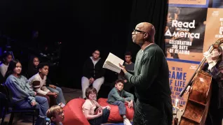 Author Kwame Alexander reads his book The Crossover to a small audience of middle school students