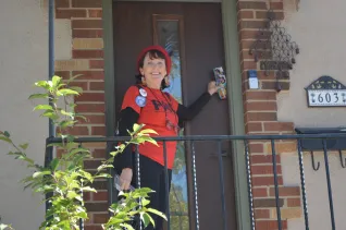 Educator in a red T-shirt canvasses to get out the vote for the school board election.