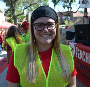 Young educator wearing glasses and neon vest helps organize CSEA events on Oct. 8