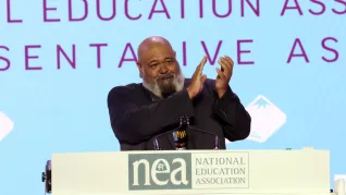 2026 ESP of the Year Ric Calhoun applauds while addressing delegates to the NEA Representative Assembly