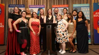 A group of people dressed in formal attire pose for a photo.
