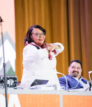 NEA President-elect Princess Moss makes a heart with her hands on stage at the NEA Representative Assembly